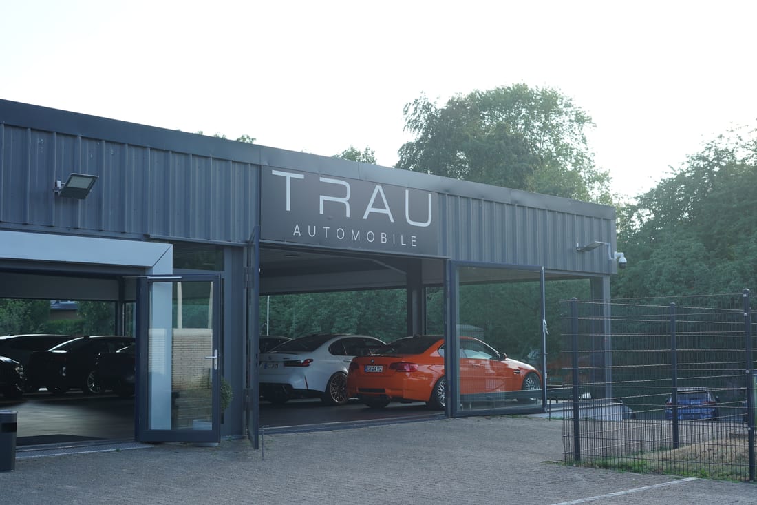 TRAU Automobile von außen — Gebäude mit Schriftzug und Einfahrt