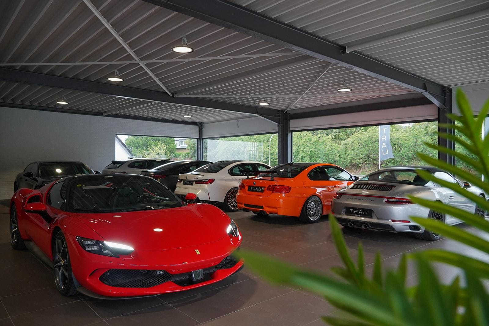 Ferrari, BMW M und Porsche 911 in der Ausstellungshalle der TRAU GmbH